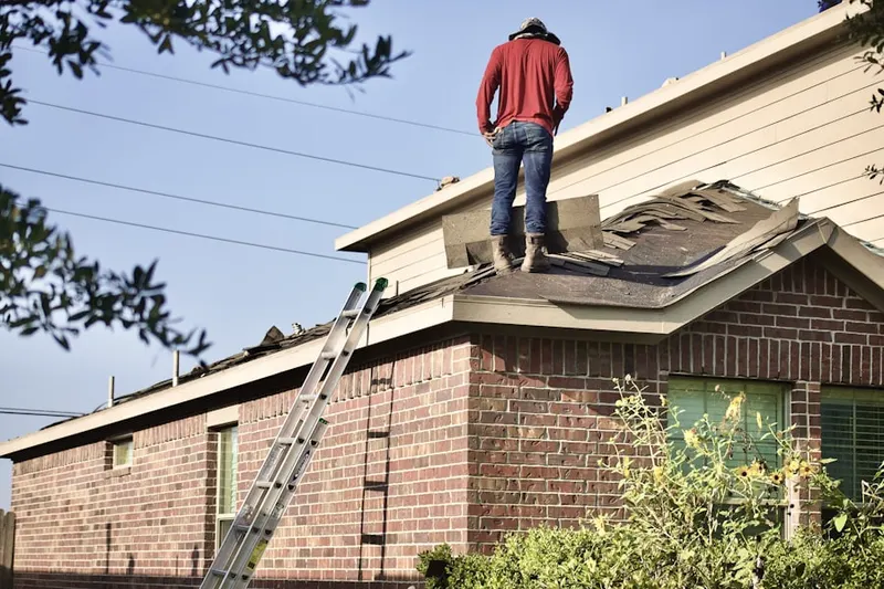 Professional roofer working on a residential roof in Idlewild